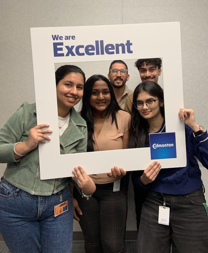 Preethi Raghuraman and City of Edmonton team members holding a We are Excellent photo frame
